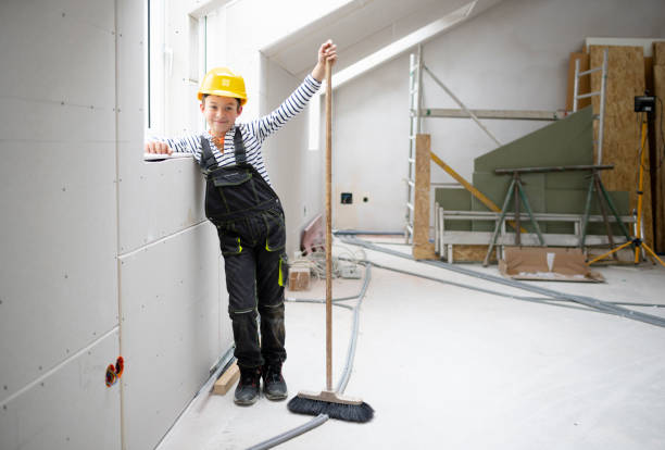 istock cool boy with yellow helmet on construction site with broom 1372164726