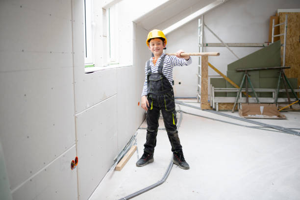 istock cool boy with yellow helmet on construction site with broom 1372164884
