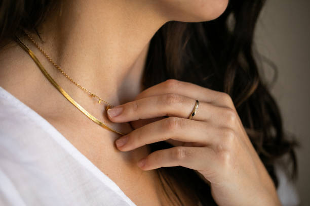 womanwith ring holding necklace Close up of young woman wearing a gold ring touching her gold necklace jewellery stock pictures, royalty-free photos & images