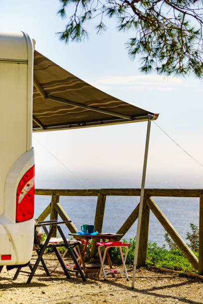 istock Camper and chairs on sea shore 1372166676