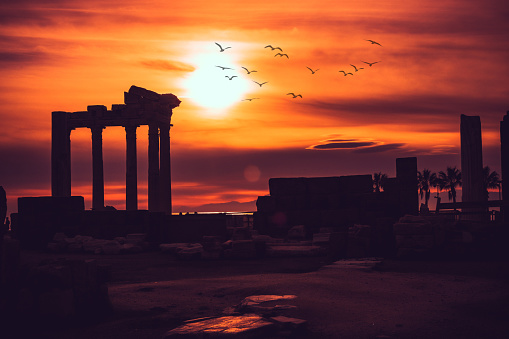 Temple of Apollon ancient ruins at sunset. Silhouette of Apollon Temple in Side antique city, Greek ancient historical antique marble columns in Side Antalya Turkey.