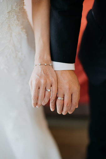 The bride is holding a wedding ring.Close up of fingers with a beautiful delicate festive manicure