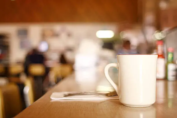 A cup of coffee on the counter at a diner.
