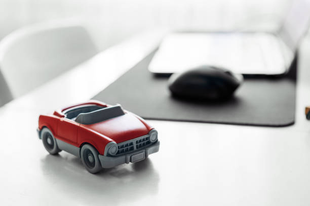 istock Red toy car on table with laptop computer 1372171358
