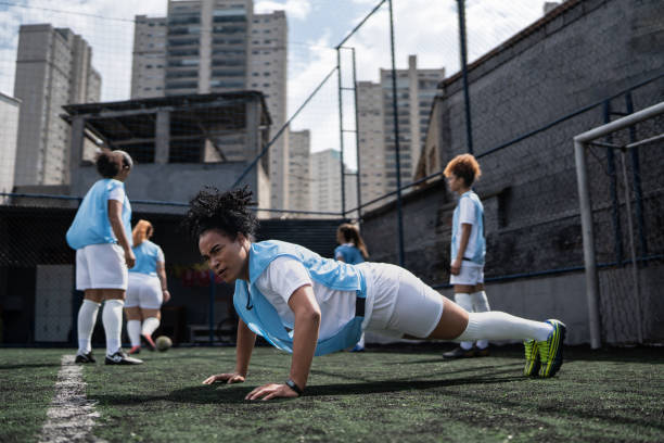 istock Female soccer pleayer doing push ups at training 1372172416