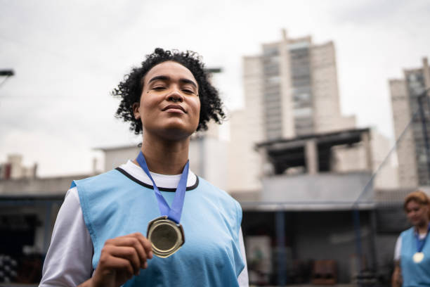 retrato de uma jogadora de futebol comemorando a conquista de uma medalha - medalist - fotografias e filmes do acervo