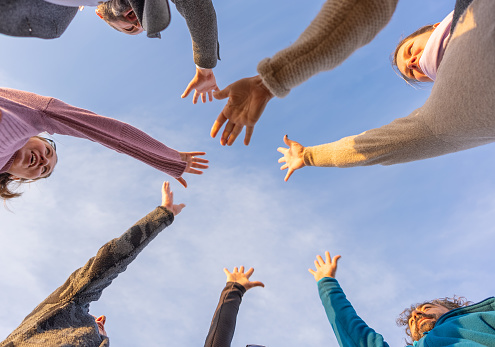 Shot of a group of friends with their hands together in a huddle