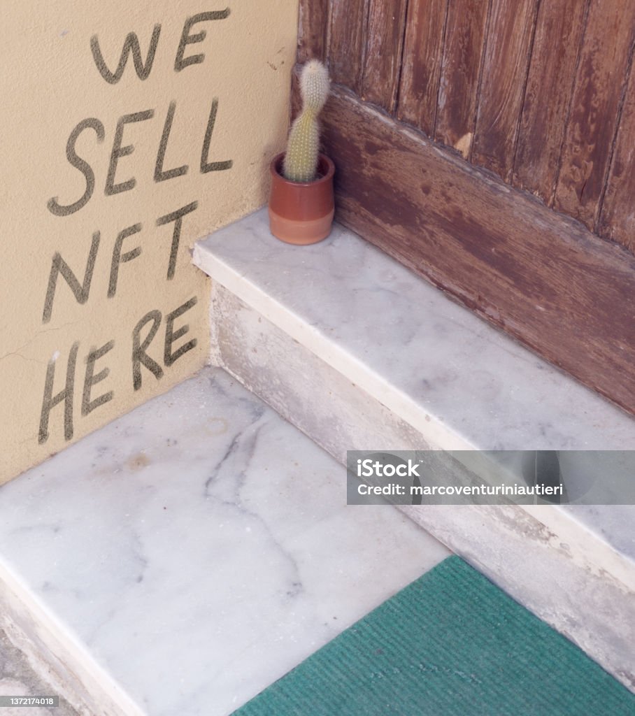 we sell nft here "WE SELL NFT HERE" is handwritten on a house wall near the entrance. Is it a scam? *** The text was digitally superimposed and a release is provided *** Non-Fungible Token Stock Photo