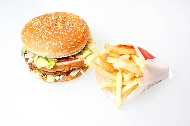 A plate of two hamburgers and fries. The focus in on the fries with a shallow depth of field.