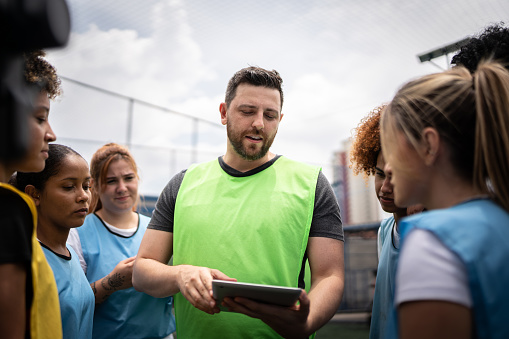 Coach and female soccer players planning a game