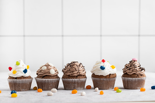 Cheerful muffins decorated with icing and candy. Stock photo