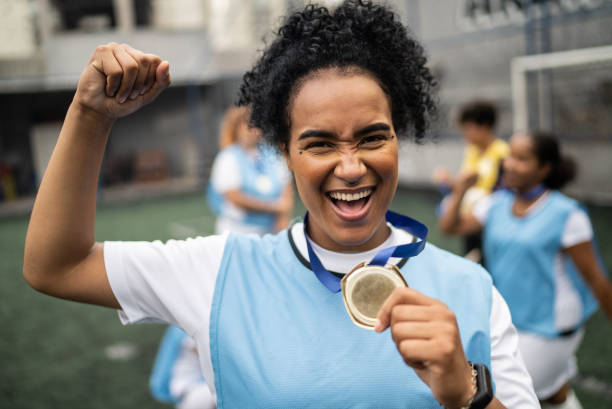 portrait d’une joueuse de soccer célébrant sa médaille - medal soccer success winning photos et images de collection