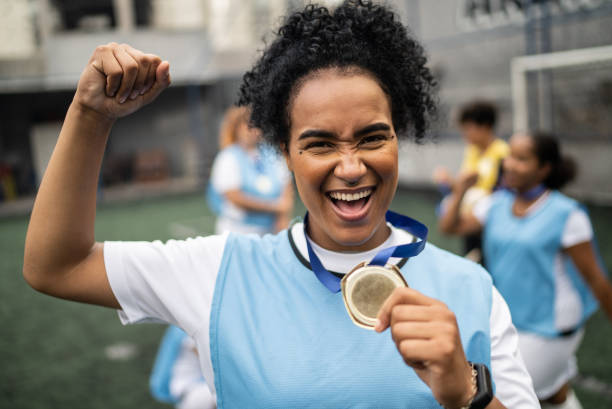 ritratto di una calciatrice che festeggia la vittoria di una medaglia - medal soccer success winning foto e immagini stock