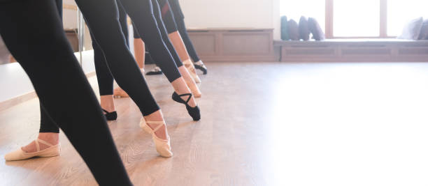 The graceful legs of ballet dancers standing in a row on their toes low section of The graceful legs of ballet dancers standing in a row on their toes low quality of life stock pictures, royalty-free photos & images