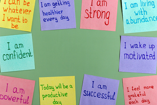 Afirmaciones positivas para todos los días: palabras en multicolor en papel para notas sobre un fondo verde. photo