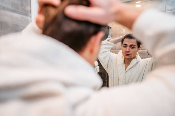 istock Young Man Looking At Himself In The Bathroom Mirror 1372177611