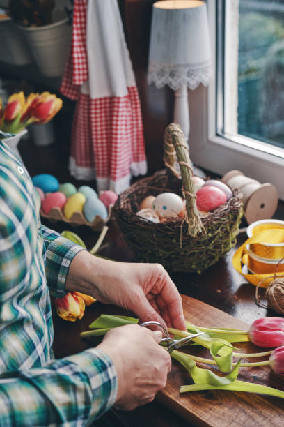 istock Preparing Easter Decoration with Tulips and Easter Eggs in Domestic Kitchen 1372177640