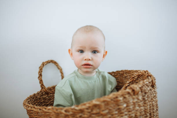 istock A little boy sits in a wicker basket and looks into the frame 1372178086
