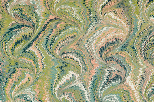 A sheet of marbled paper in green and pink colour.