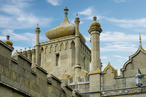 The ancient Vorontsov Palace in Alupka (Crimea) on a summer sunny day against the blue sky. Luxurious diabase palace with many towers, stone domes and stone carvings. Decorative elements on the facade