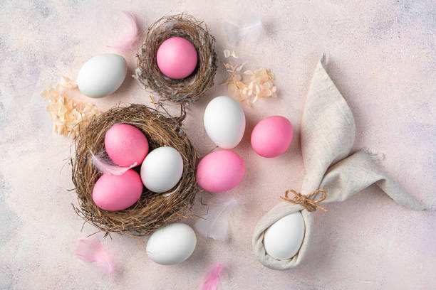 istock Delicate Easter background with a rabbit from a napkin and pink and white eggs on a delicate pink background 1372187082