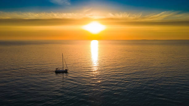 istock Yacht sails to the horizon in the setting sun 1372188498