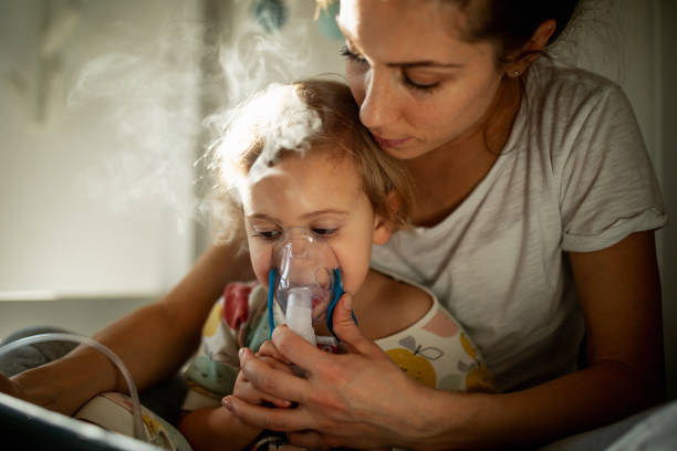 mutter kümmert sich kranken kind - nebulizer stock-fotos und bilder