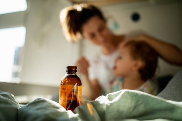 madre de niño cuidado de sick - jarabe para la tos fotografías e imágenes de stock