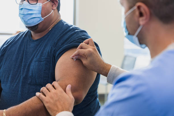 istock Doctor prepares to inject mature man 1372189812