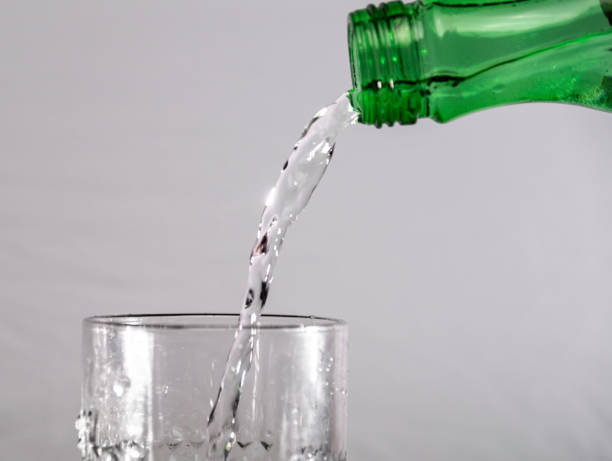 istock Glass with running clean water and gray background 1372189947