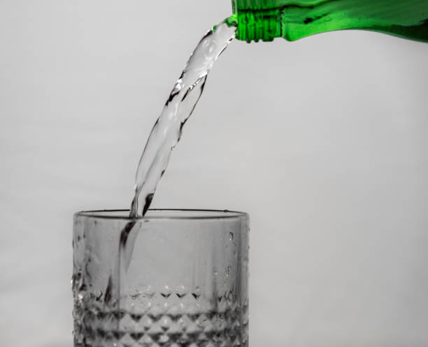 istock Glass with running clean water and gray background 1372189948