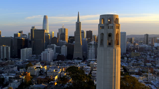 Extreme Aerial Drone view close up of Coit Tower and San Francisco at Sunset