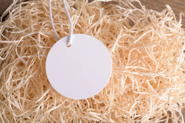 istock Round white label tag mockup on a natural straw material for packing, close up. 1372193330