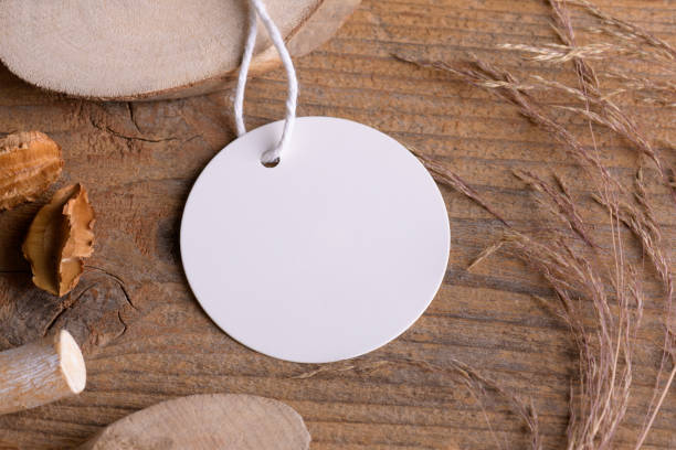istock Round white tag mockup on a rustic wooden background with cotton string and boho decoration 1372193342