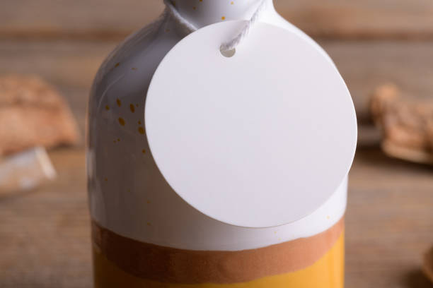 istock Round white tag mockup on ceramic bottle for olive oil a wooden background with boho decoration, element for packing 1372193349
