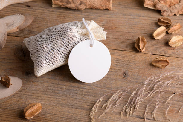 istock Round white gift tag mockup on gift packet on rustic wooden background with boho decoration. 1372193391