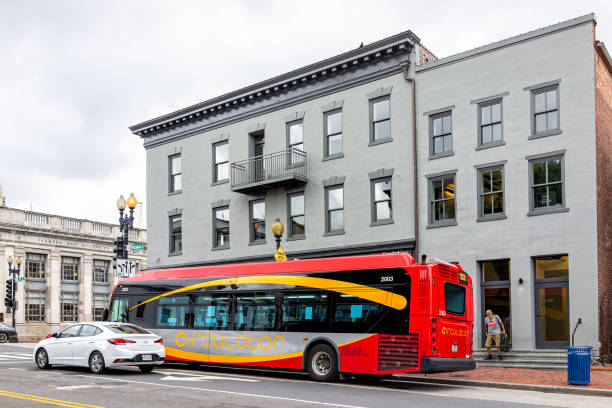 georgetown m street with buildings in university neighborhood and red circulator bus in traffic public transportation - bus transportation georgetown washington dc washington dc imagens e fotografias de stock