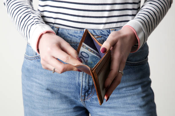 Woman looking at last euros in her wallet stock photo