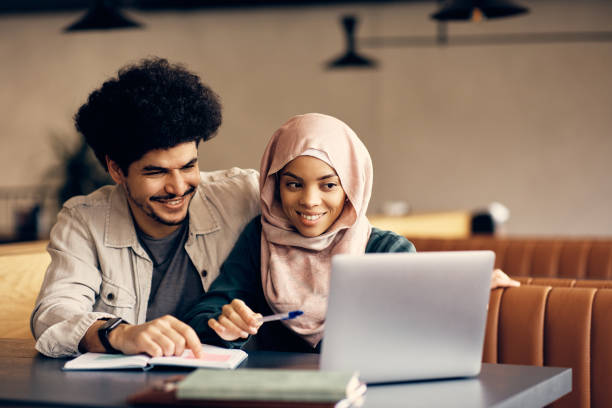 istock Happy Middle Eastern couple e-learning on laptop at university cafeteria. 1372198661