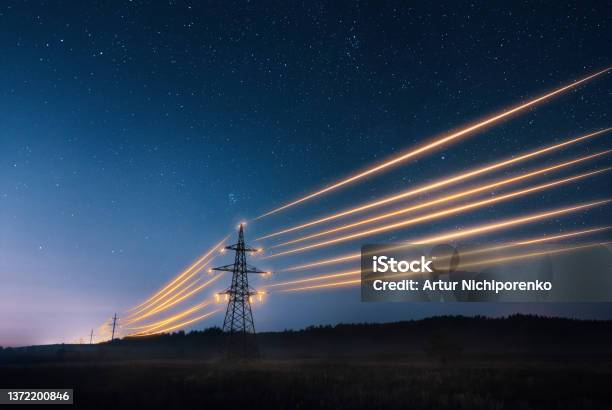 Electricity Transmission Towers With Orange Glowing Wires Against Night Sky-foton och fler bilder på Elektricitet