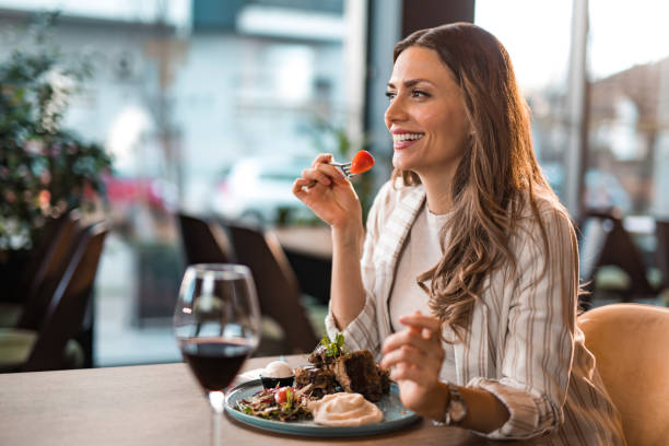 istock Happy young woman eating lunch at a restaurant. 1372203097