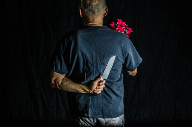 istock Man holding kitchen knife and flowers 1372203103