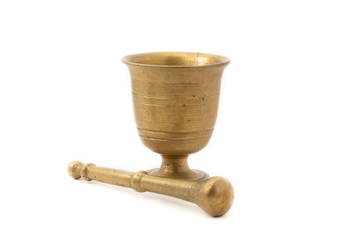 Old golden brass mortar and pestle isolated on white background.