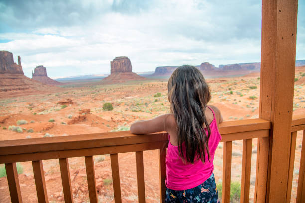 berühmter ort. usa. utah. junges touristenmädchen im urlaub von der terrasse des boungalow mit blick auf die schönheit des monument valley - monument valley navajo mesa monument valley tribal park stock-fotos und bilder