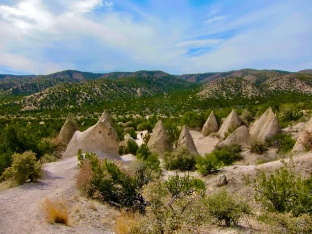 Exploring Kasha-Katuwe Tent Rocks National Monument A hiker makes his way amongst the Kasha-Katuwe Tent Rocks. The name is derived from the term for white cliffs in the Keresan language of the area's Puebloan people. Located in the foothills of the Jemez Mountains near Cochiti Pueblo, 35 miles southwest of Santa Fe, New Mexico. January 28, 2016. kasha katuwe tent rocks stock pictures, royalty-free photos & images