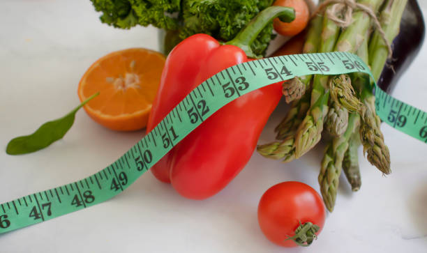 istock fresh vegetables, measuring tape on wooden background 1372212931
