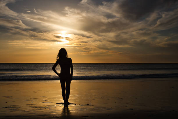 istock Woman on the beach at sunset 1372214350