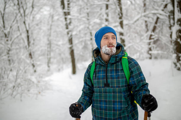 Young handsome man in ski sportswear in mountain and looking away