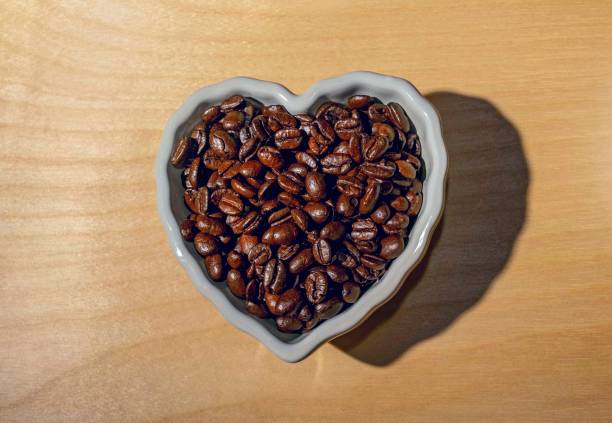 istock Coffee beans inside a heart shaped white bowl 1372218508