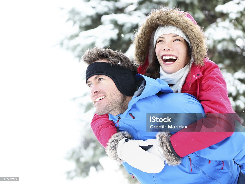 Inverno di coppia felice piggyback - Foto stock royalty-free di 25-29 anni